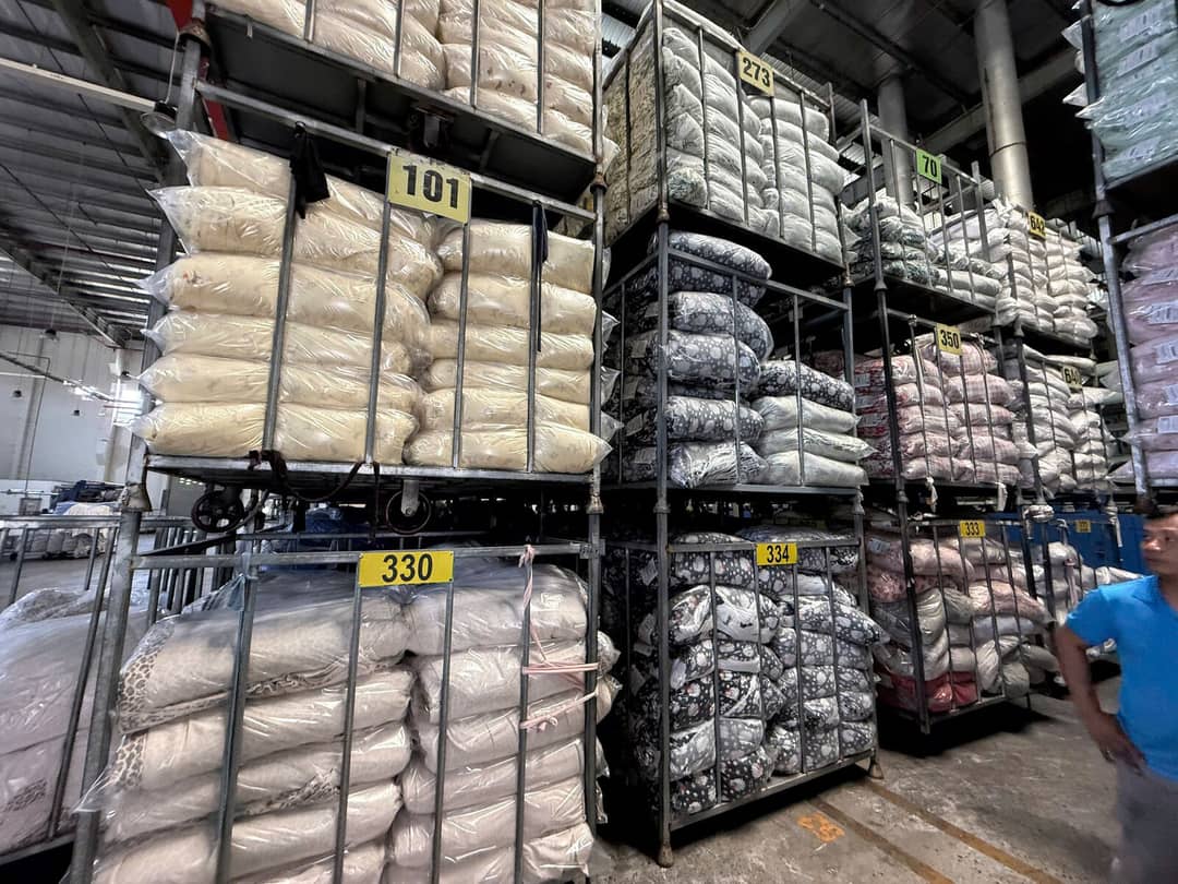 Row of numbered fabric racks in a factory warehouse